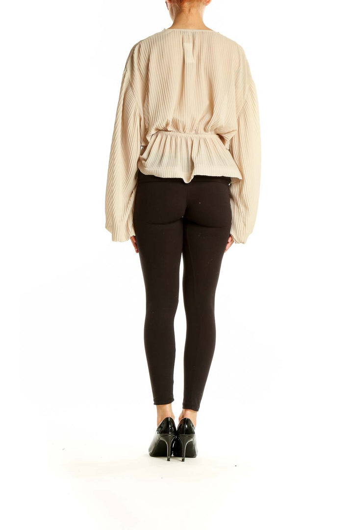 Back view of beige pleated crop top showing full length and fit