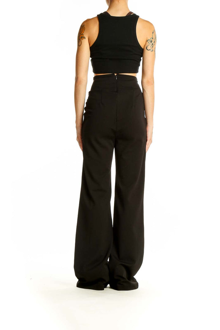 Side view of model wearing black wide-leg dress pants and crop top