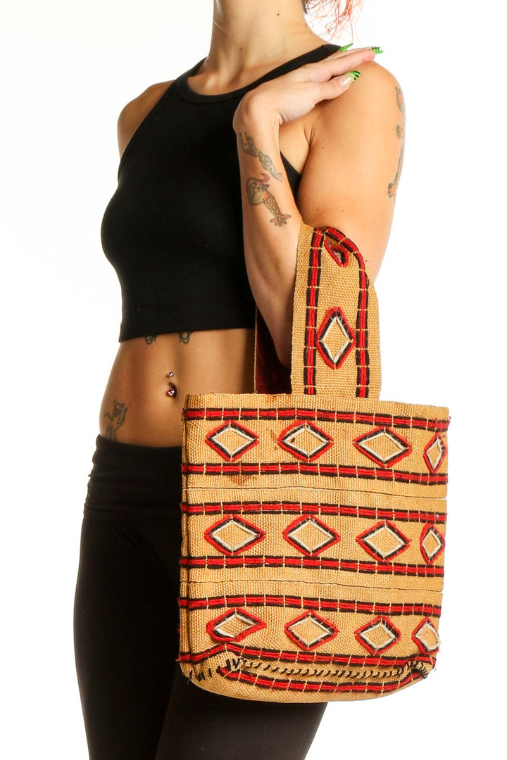 Front view of tan SilkRoll shoulder bag with red and orange geometric pattern