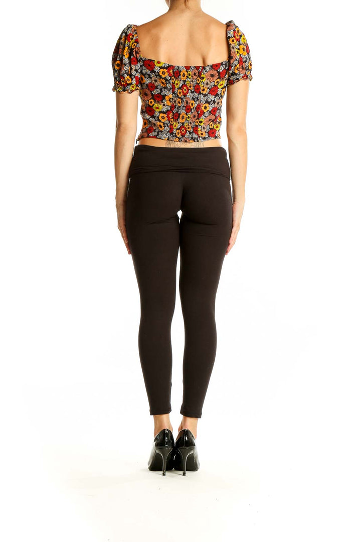 Back view of Urban Revivo multicolor floral puff sleeve crop top with black pants