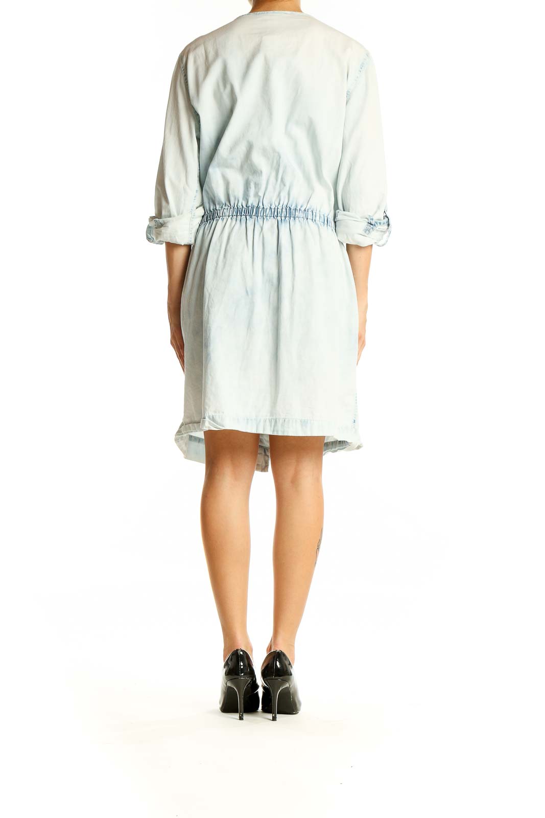 Back view of Michael Kors light blue denim shirt dress showing cinched waist and rolled-up sleeves