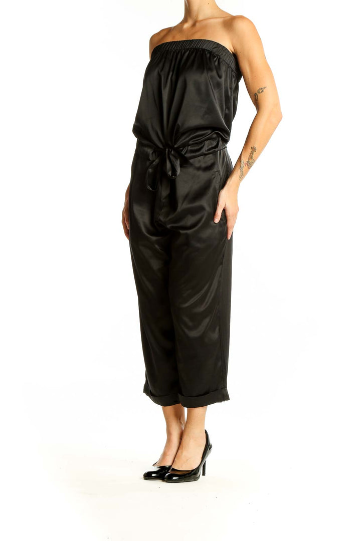 Front view of black strapless satin jumpsuit with tie waist