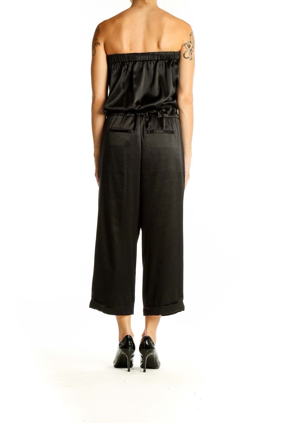 Side view of black strapless satin jumpsuit showing wide-leg design