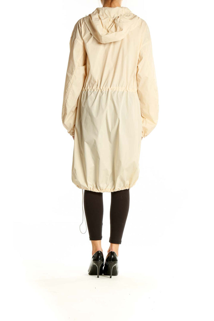 Back view of Uniqlo beige hooded parka jacket showing full length