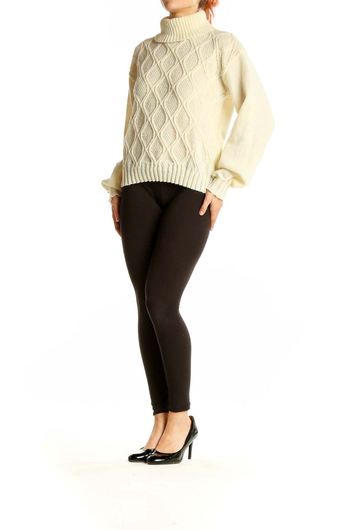 Front view of cream cable knit turtleneck sweater with diamond pattern