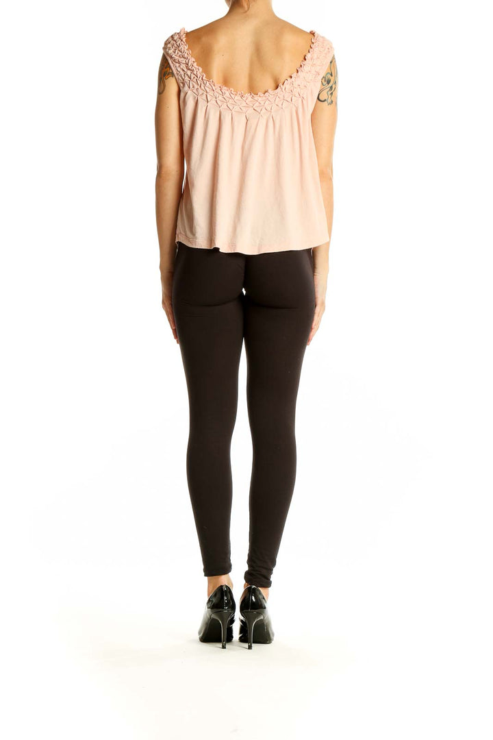 Side view of Maeve blush sleeveless top paired with black pants