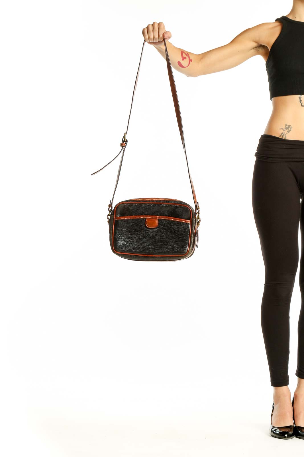 Front view of black leather Coach crossbody bag with brown trim