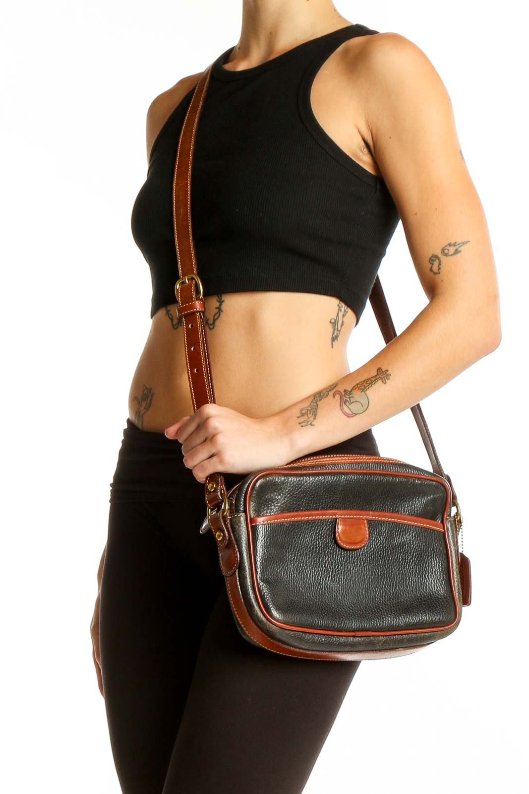 Front view of black leather Coach crossbody bag with brown trim