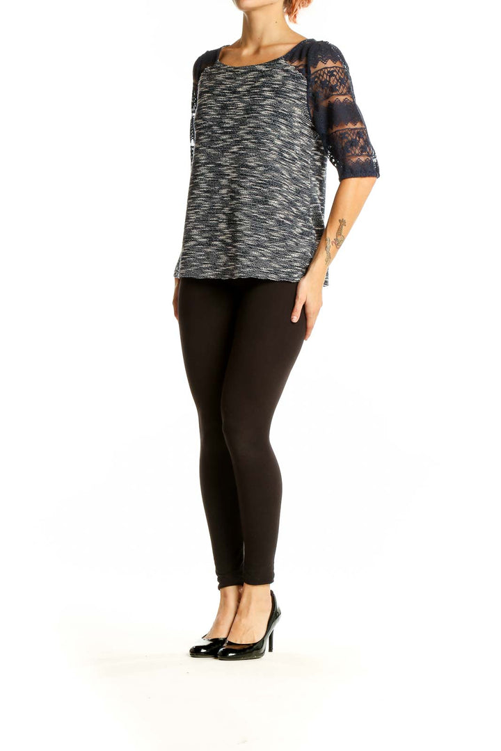 Front view of Anthropologie black and white marled top with navy lace sleeves