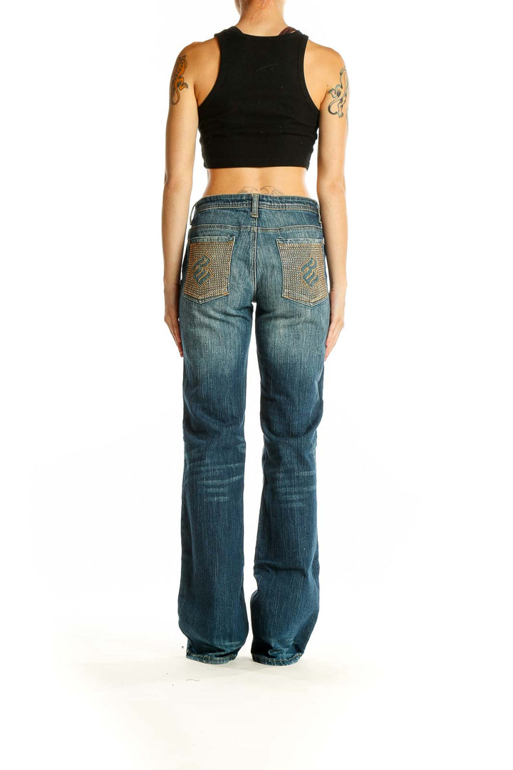 Back view of Rocawear blue distressed wide-leg jeans on model with black crop top