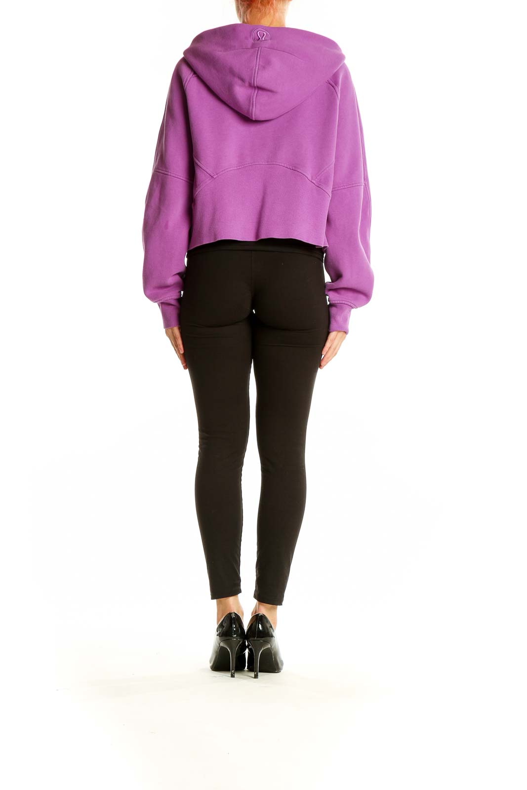 Back view of purple Lululemon cropped zip-up hoodie on model with black leggings