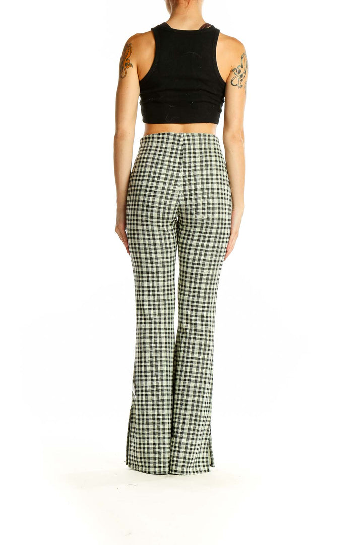 Side view of ASOS green gingham check flared pants on model with black crop top