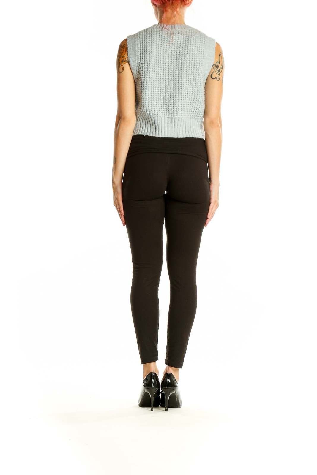 Side view of Jessica Simpson mint green cropped sleeveless sweater paired with black pants