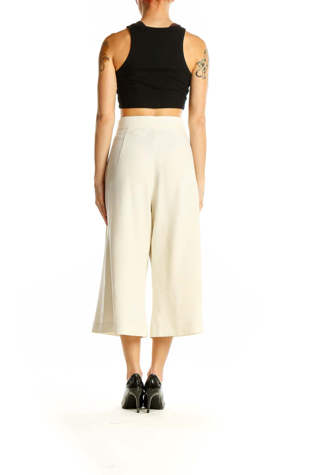 Side view of model wearing French Connection cream wide-leg cropped trousers with black top