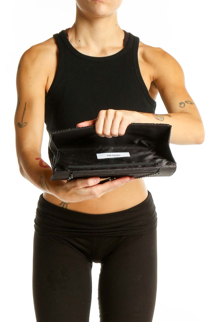 Model holding Jessica McClintock black textured clutch, showcasing size and style