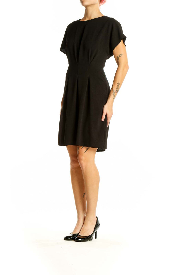 Front view of black ASOS mini dress with pleated waist and short sleeves