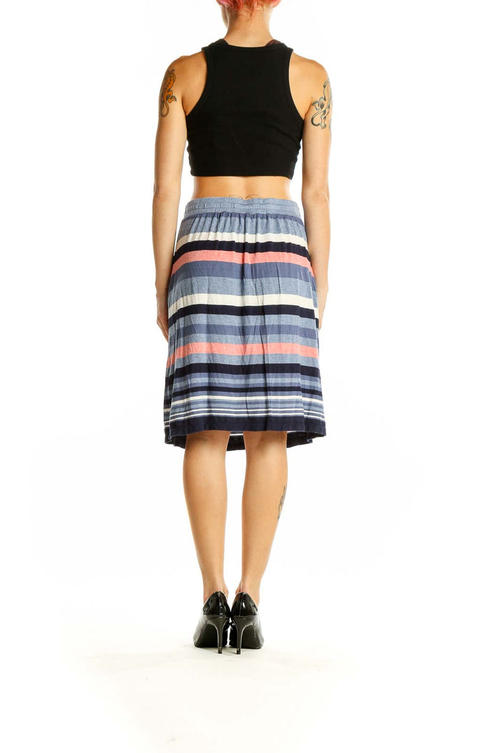 Side view of model wearing Max Studio blue striped midi skirt with black top