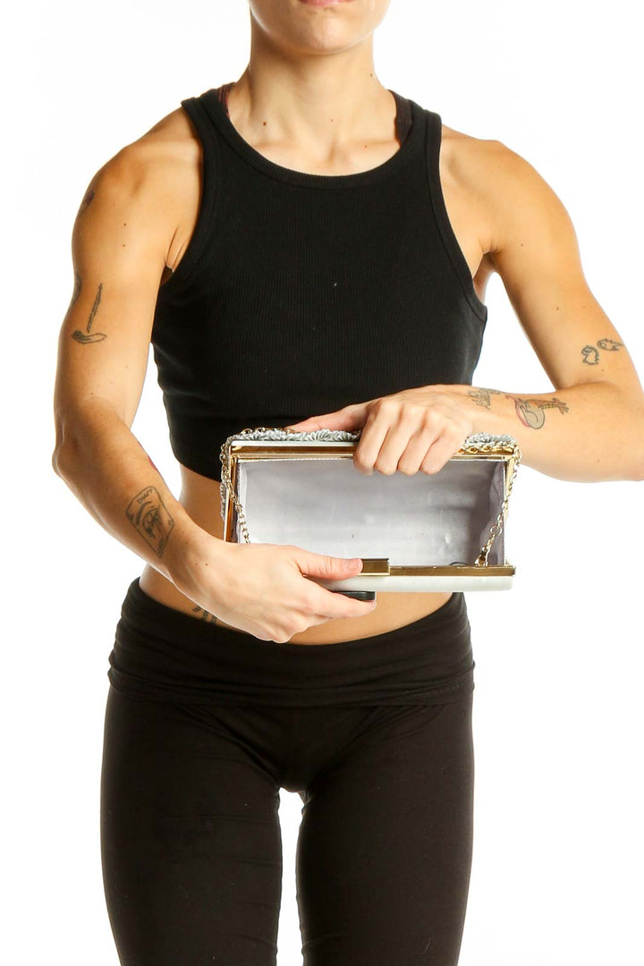 Kate Landry silver clutch worn with black outfit, showcasing size and versatility