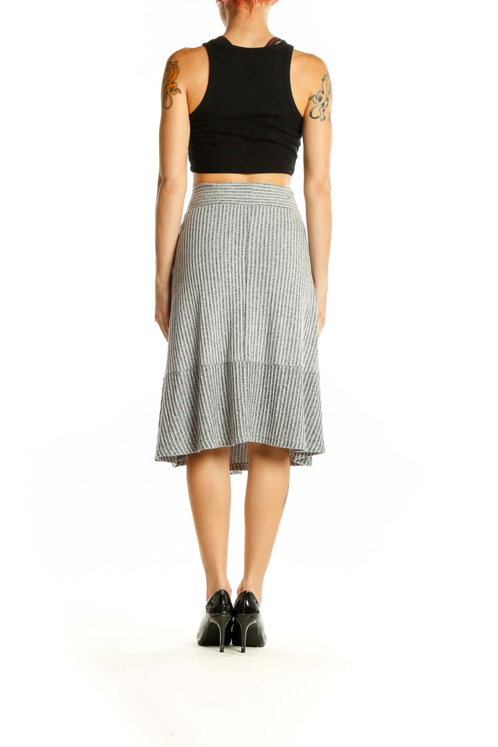 Side view of gray ribbed A-line midi skirt paired with black top