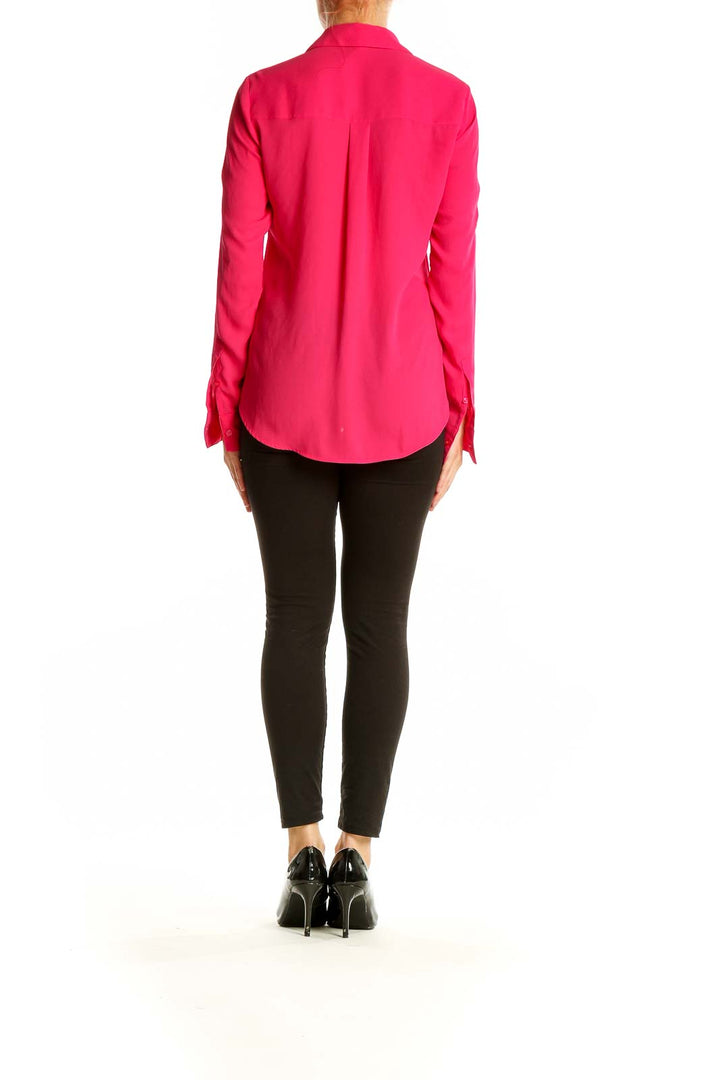 Side view of woman wearing hot pink Express blouse with black pants