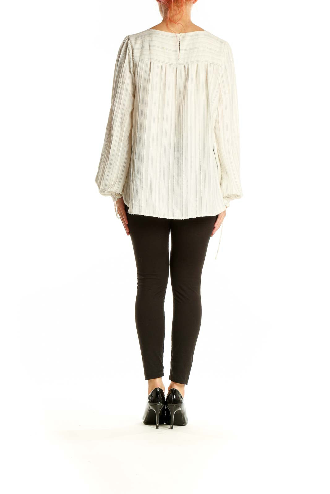 Back view of LOFT white striped flowy polyester blouse on model with black pants