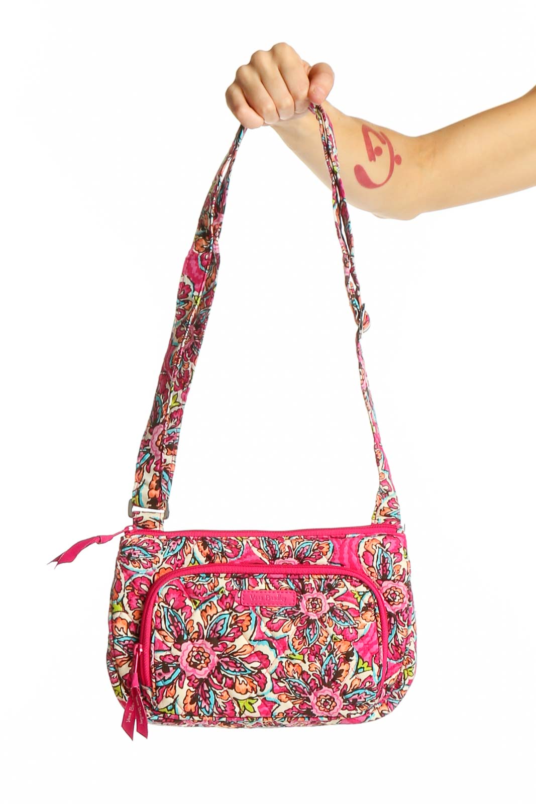 Front view of Vera Bradley pink floral crossbody bag held by hand