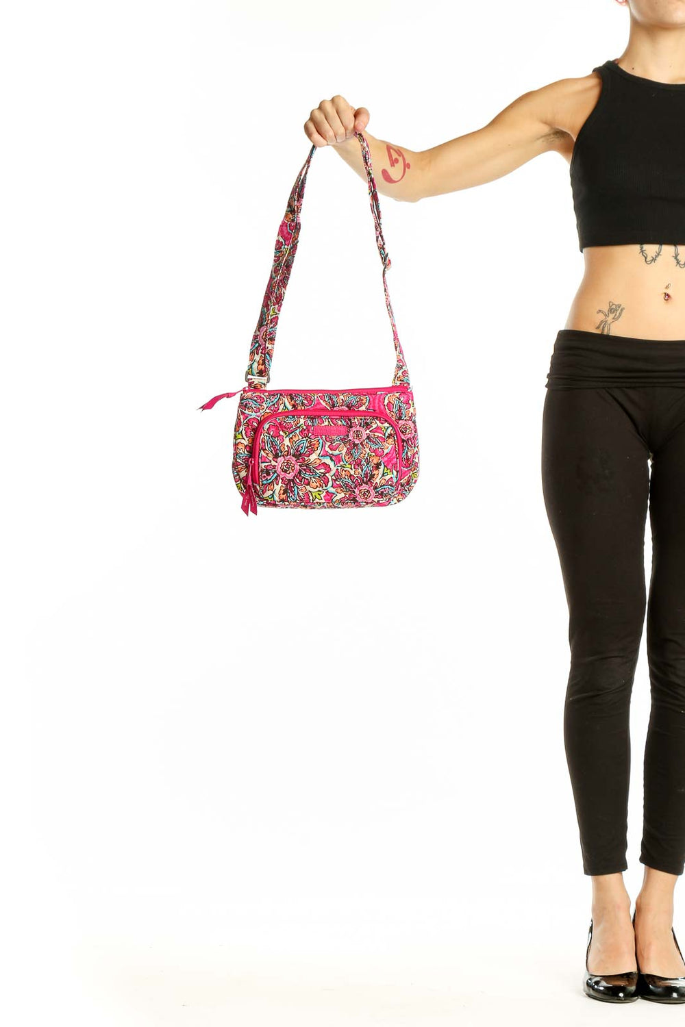 Front view of Vera Bradley pink floral crossbody bag held by hand