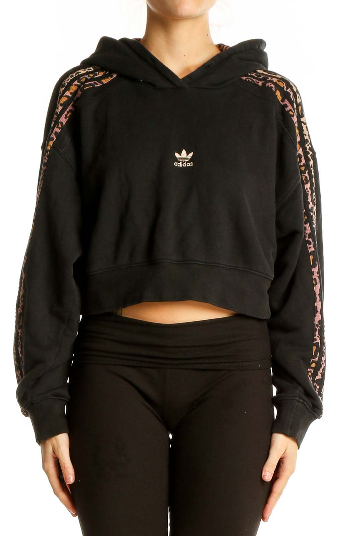 Front view of Adidas black cropped hoodie with leopard print stripes on sleeves