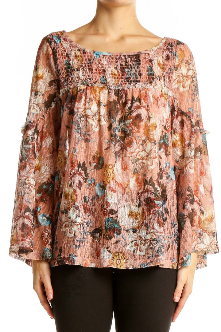 Front view of Akemi + Kin pink floral bell sleeve blouse with smocked neckline