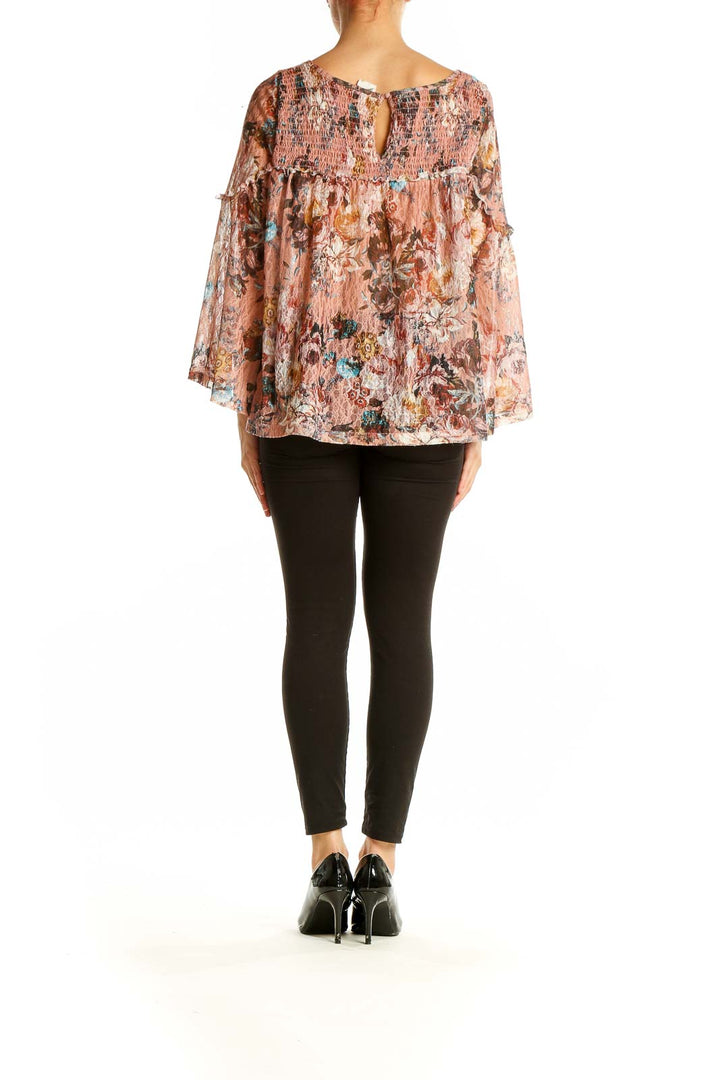 Back view of Akemi + Kin pink floral bell sleeve blouse showing loose fit