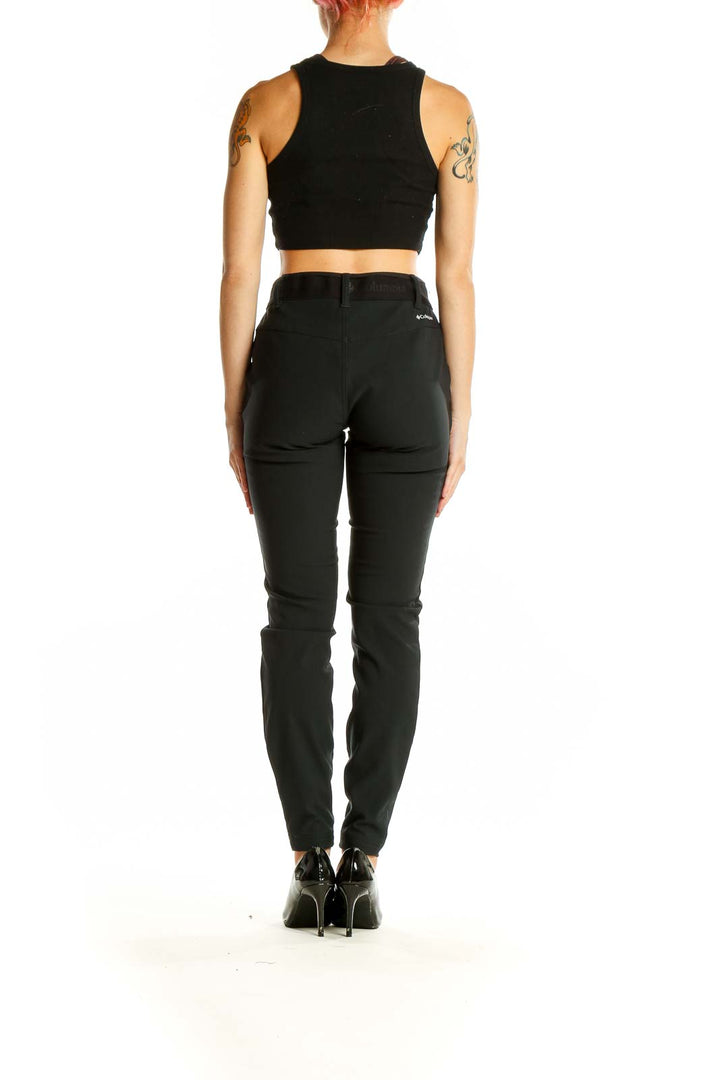 Side view of woman wearing black Columbia slim-fit performance pants