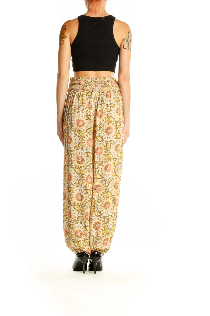 Side view of model wearing yellow floral harem pants with black crop top