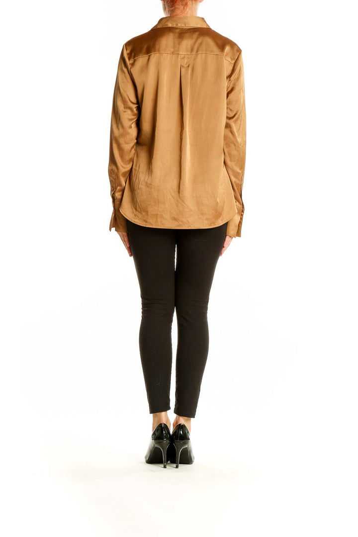 Back view of Banana Republic camel satin button-down blouse on model with black pants