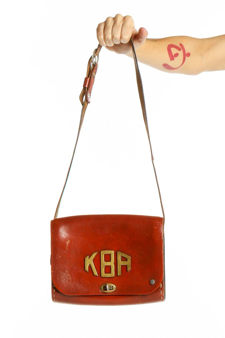 Front view of red vintage Thom Hird leather crossbody bag with gold KBA initials