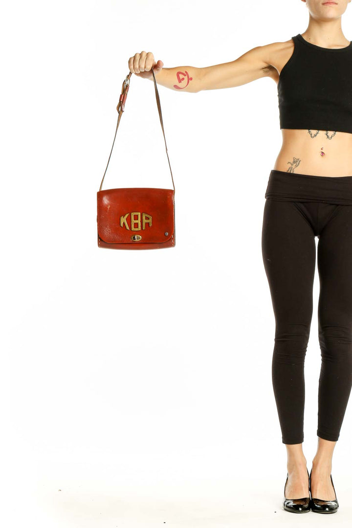 Front view of red vintage Thom Hird leather crossbody bag with gold KBA initials