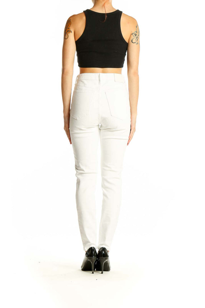 Side view of Everlane white high-waisted slim fit jeans on model with black crop top