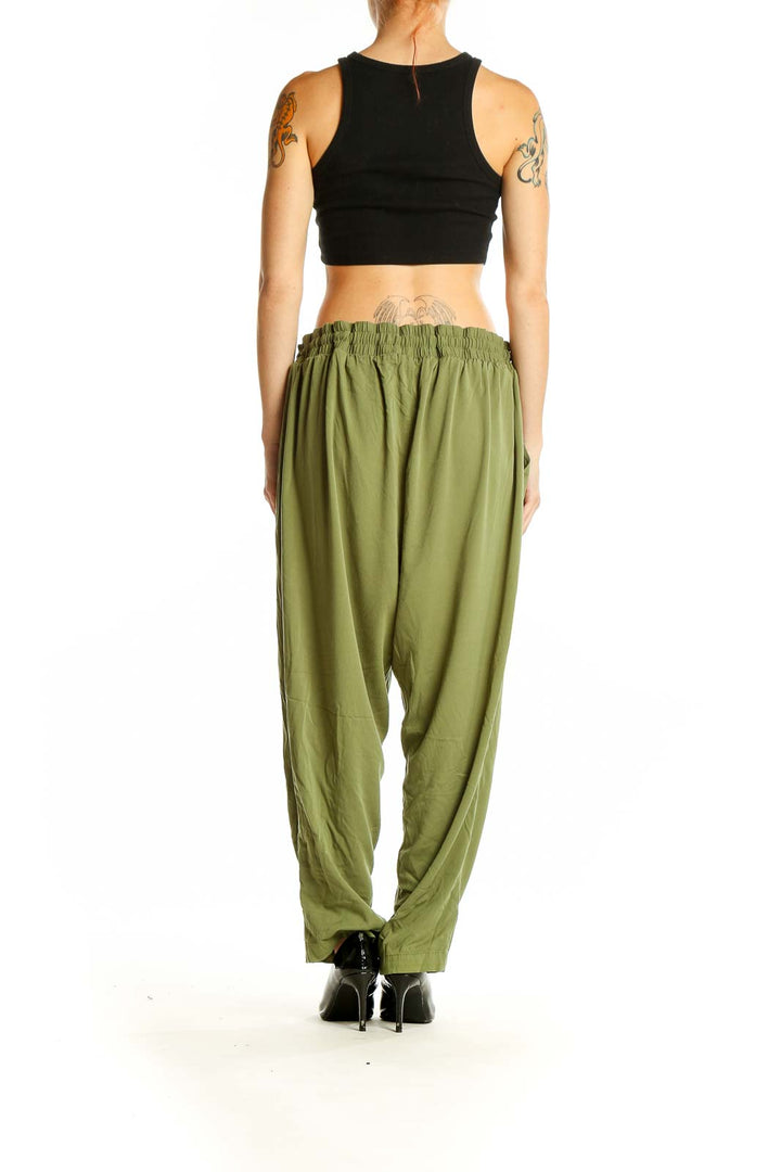 Side view of model wearing olive green relaxed-fit pants from Torrid with black top