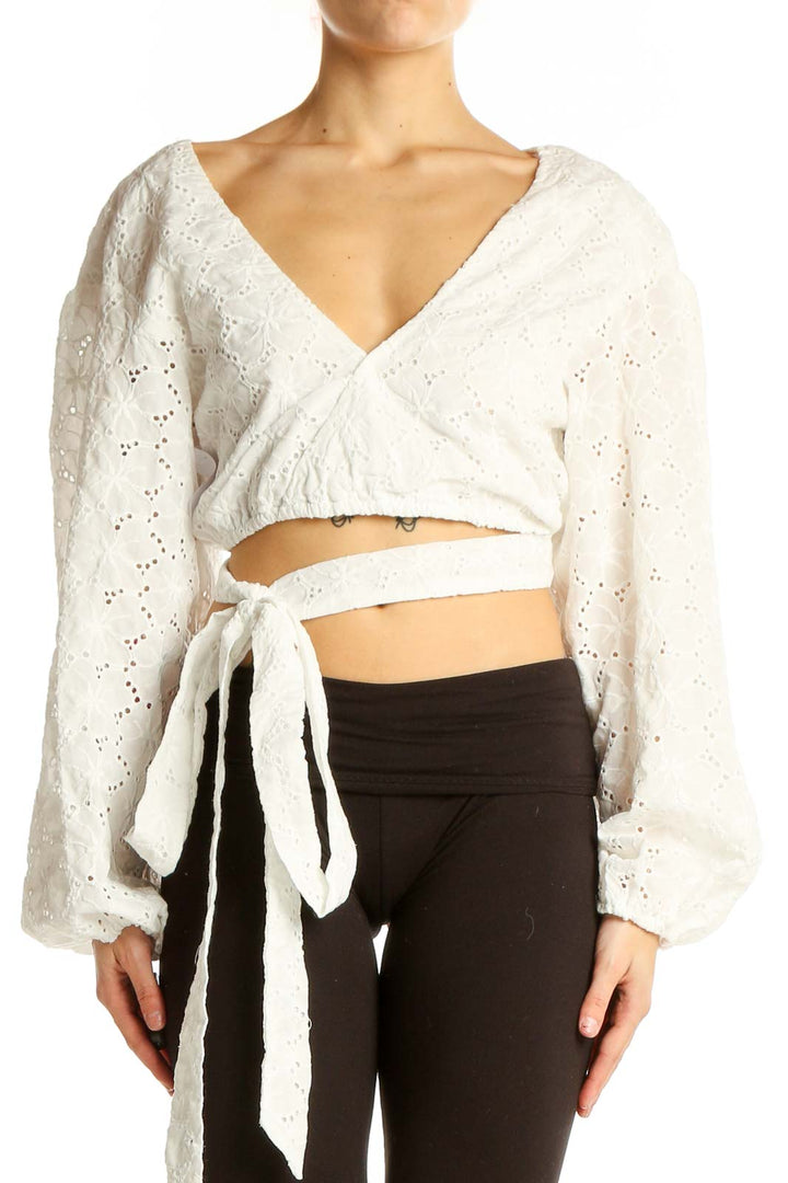 Front view of white eyelet lace wrap crop top with balloon sleeves