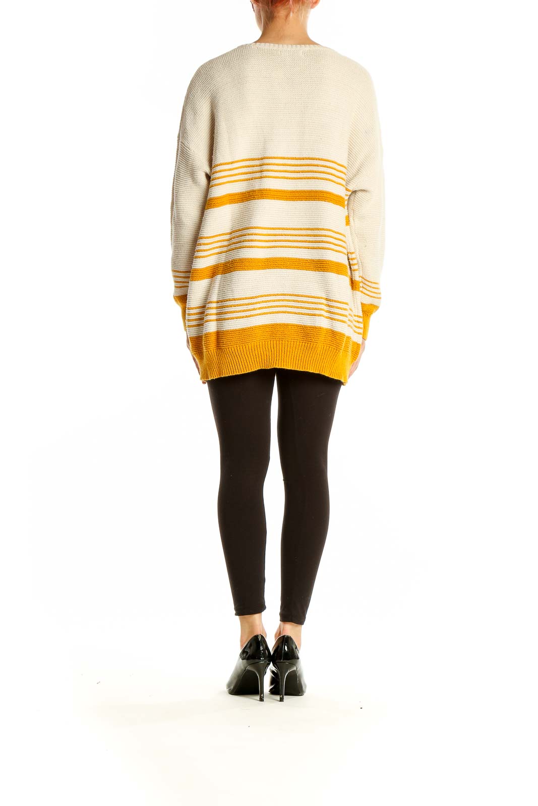 Side view of model wearing BDG cream and yellow striped oversized sweater with black leggings