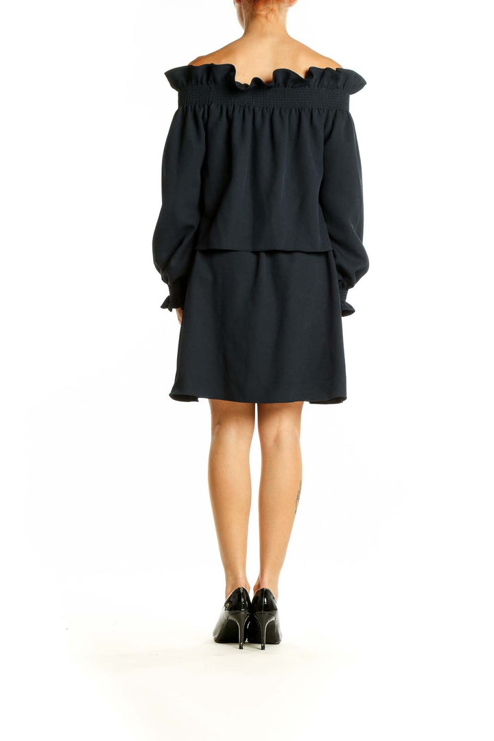 Side view of black off-shoulder ruffled mini dress by Diane von Furstenberg