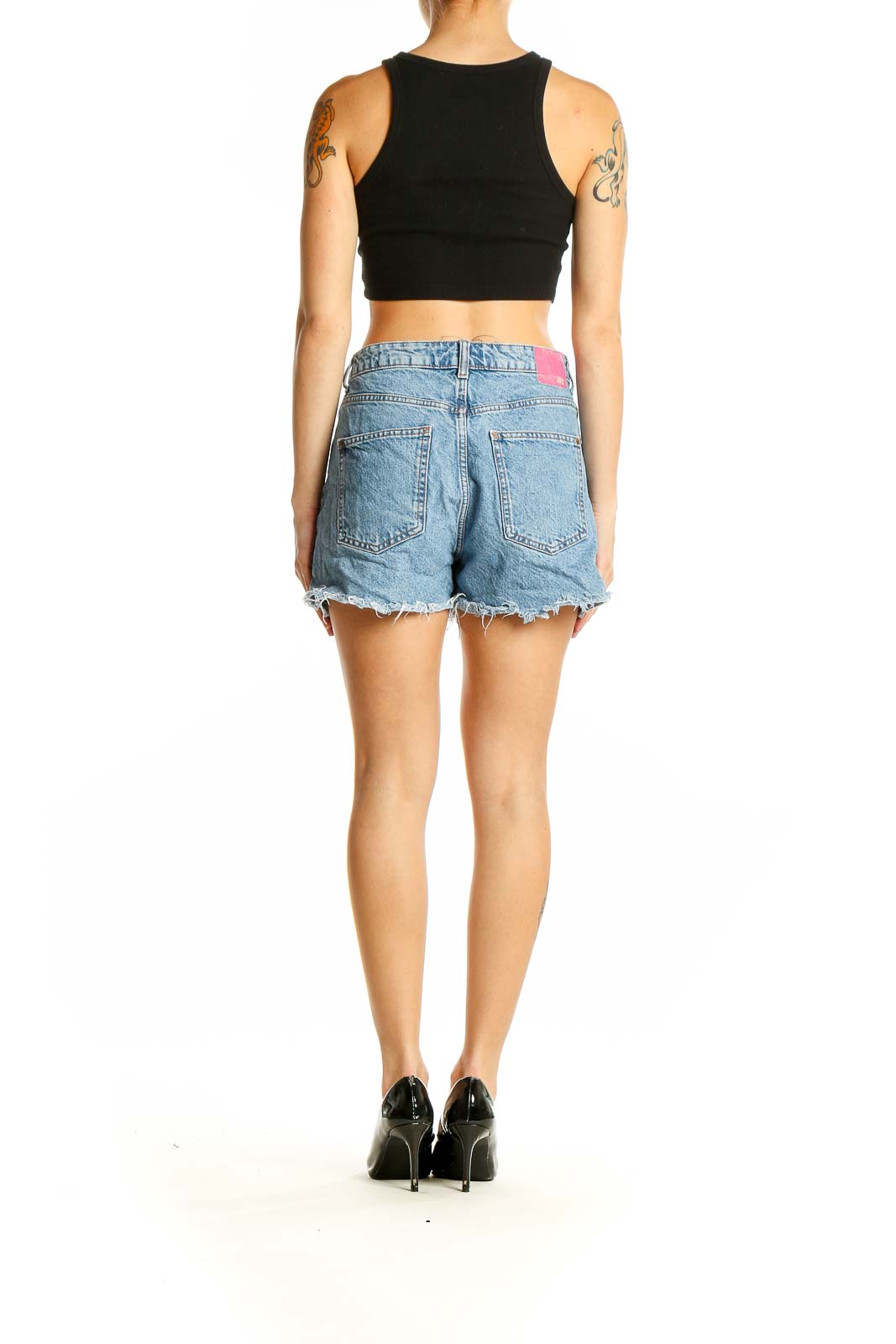 Side view of model wearing Zara light blue denim shorts with black crop top