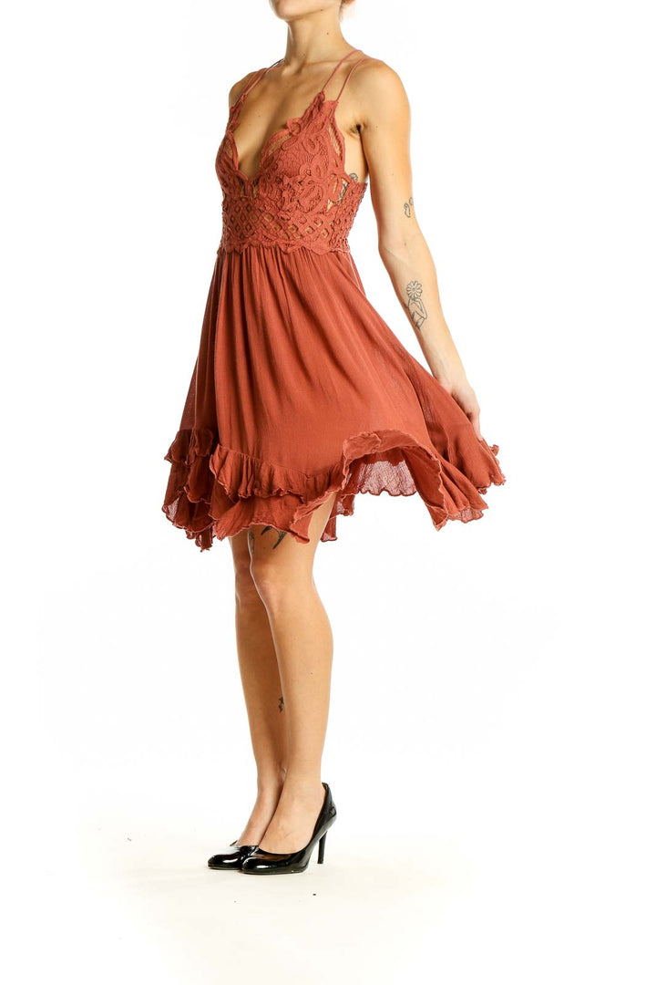 Front view of Free People terracotta mini dress with lace bodice and flowy skirt