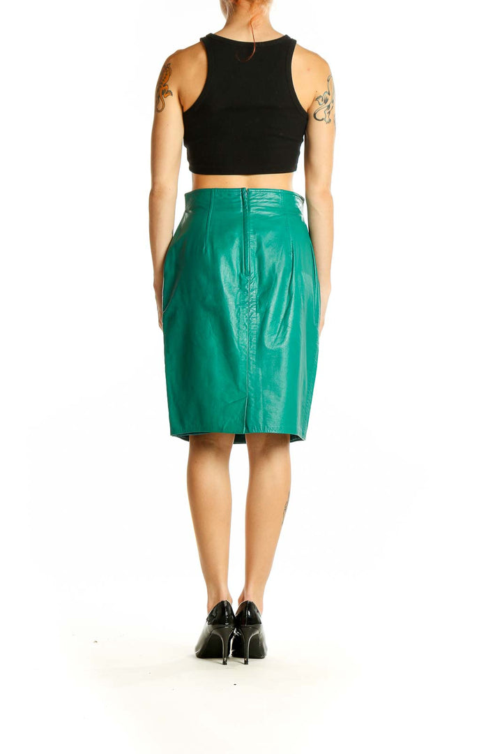 Side view of model wearing green leather pencil skirt by JOSEPH HO with black top