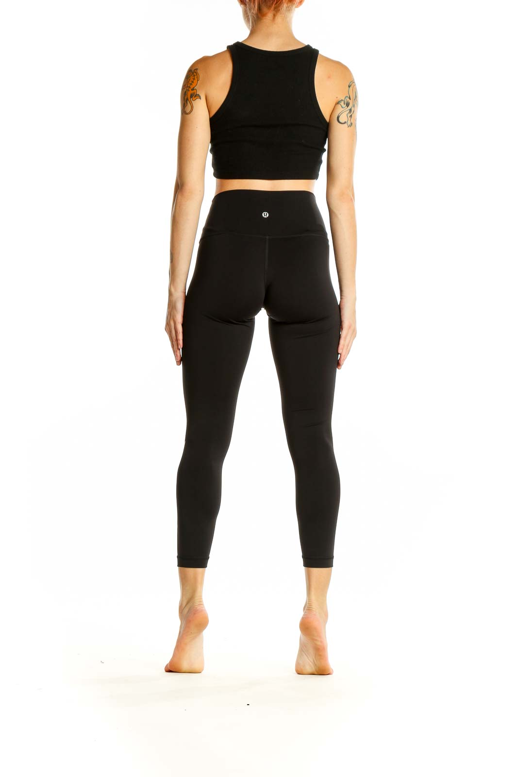 Side view of woman wearing Lululemon black high-waisted leggings with lightning bolt graphic