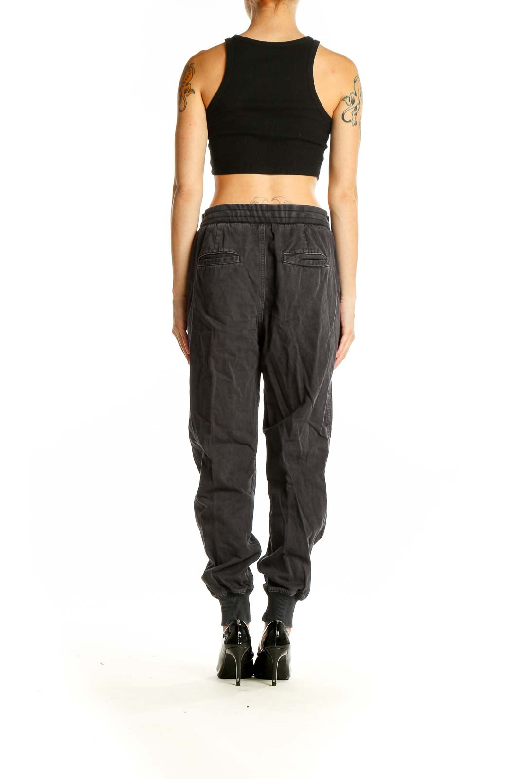 Side view of woman wearing black Gap jogger pants with crop top