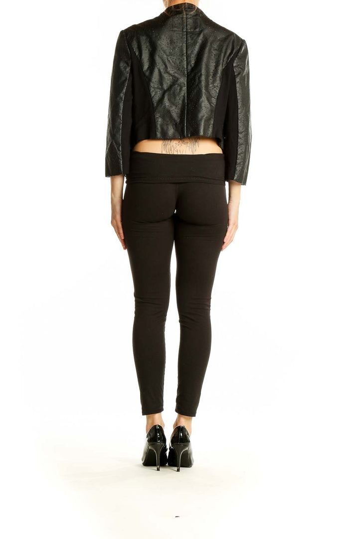 Back view of BCBG MaxAzria black perforated jacket showing cropped length