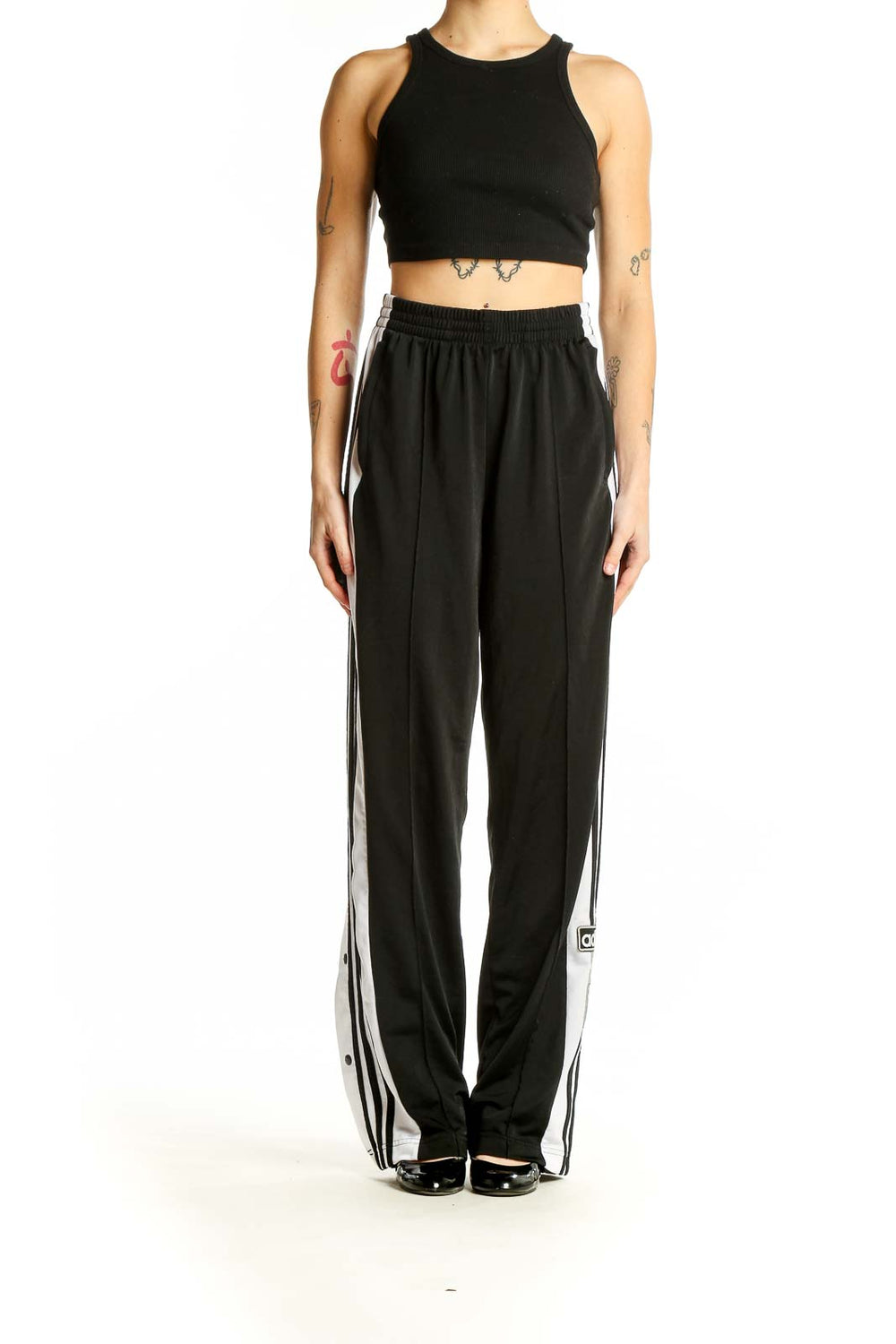 Front view of black Adidas track pants with white side stripes