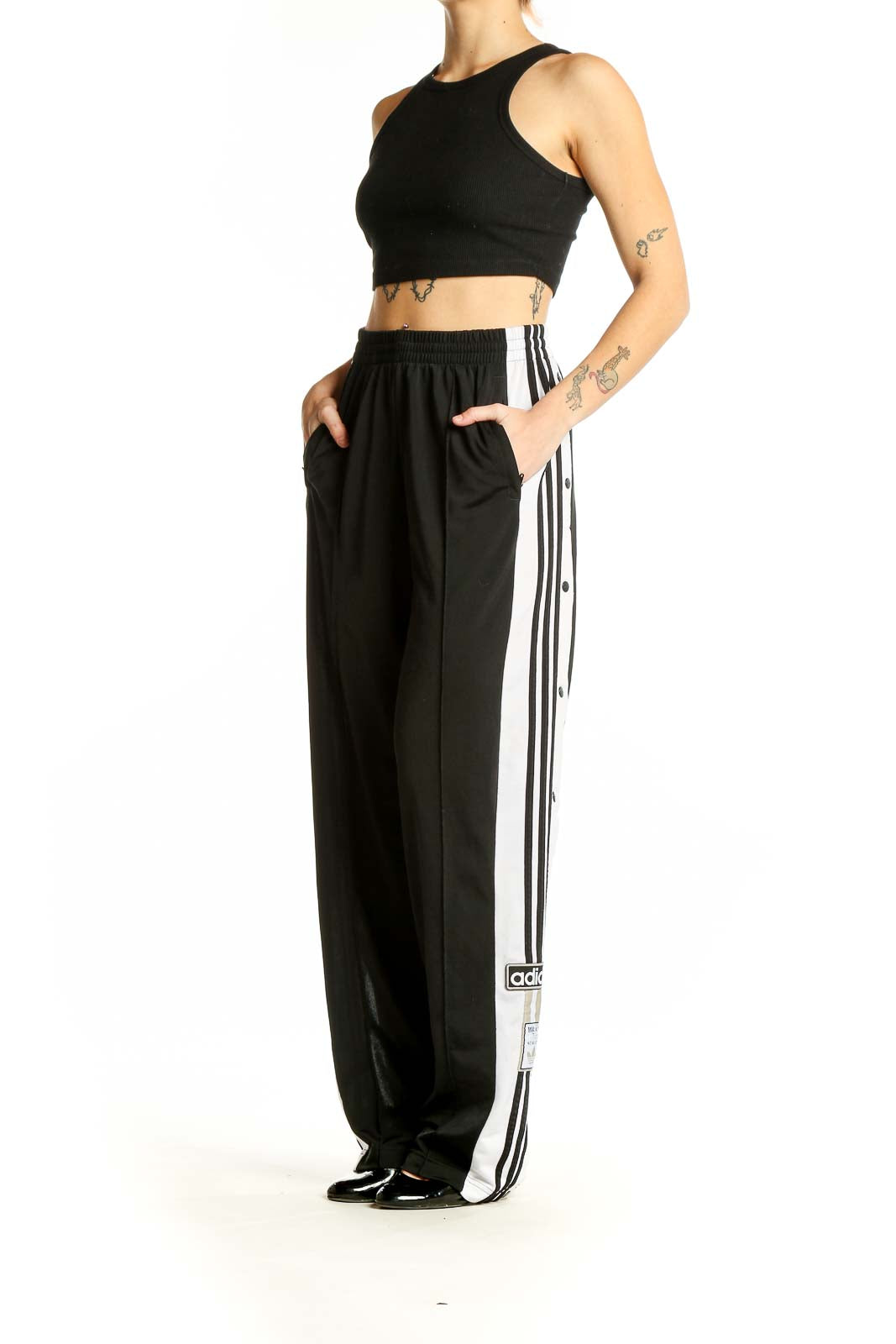 Front view of black Adidas track pants with white side stripes