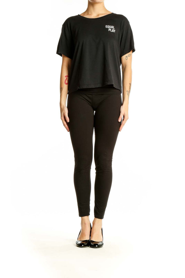 Front view of black Athleta cropped athletic top with EQUAL PLAY text