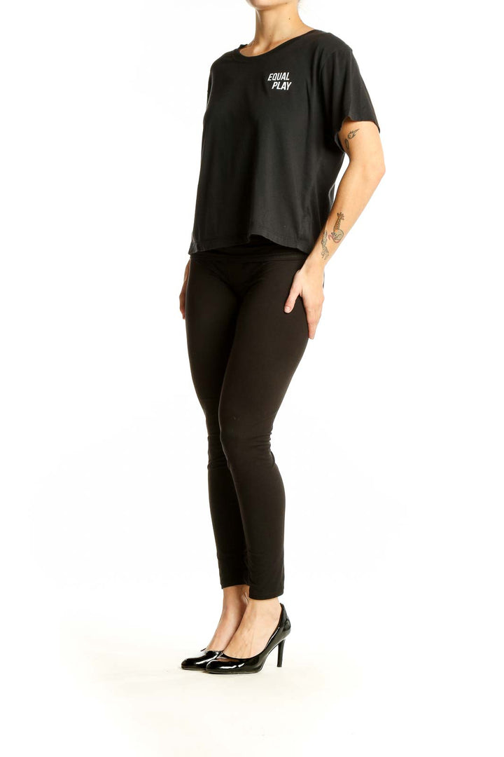 Front view of black Athleta cropped athletic top with EQUAL PLAY text